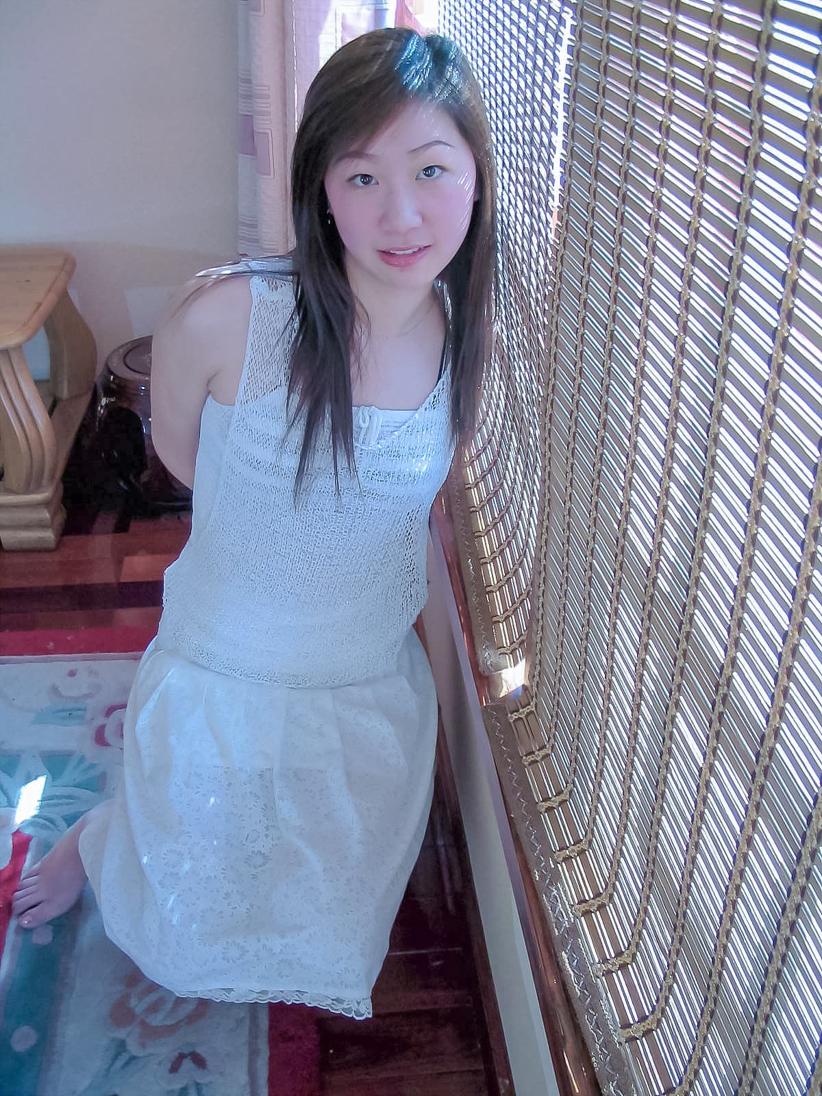 Model Hongtong's feet in sheer stockings, toes elegantly posed, glossy nylon catching studio highlights